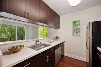 A kitchen with brown cabinets and a black refrigerator.